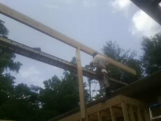 Carpenter setting a ridge beam over a new addition frame — Ice Dam Removal by Roofing Brothers in East Branch