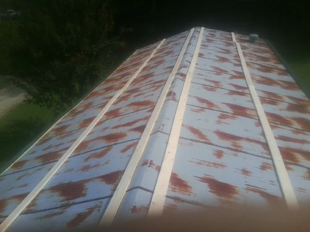 Rusted metal roof panels with new wood purlins before replacement — Storm Damage Roof Repair in East Branch by Roofing Brothers