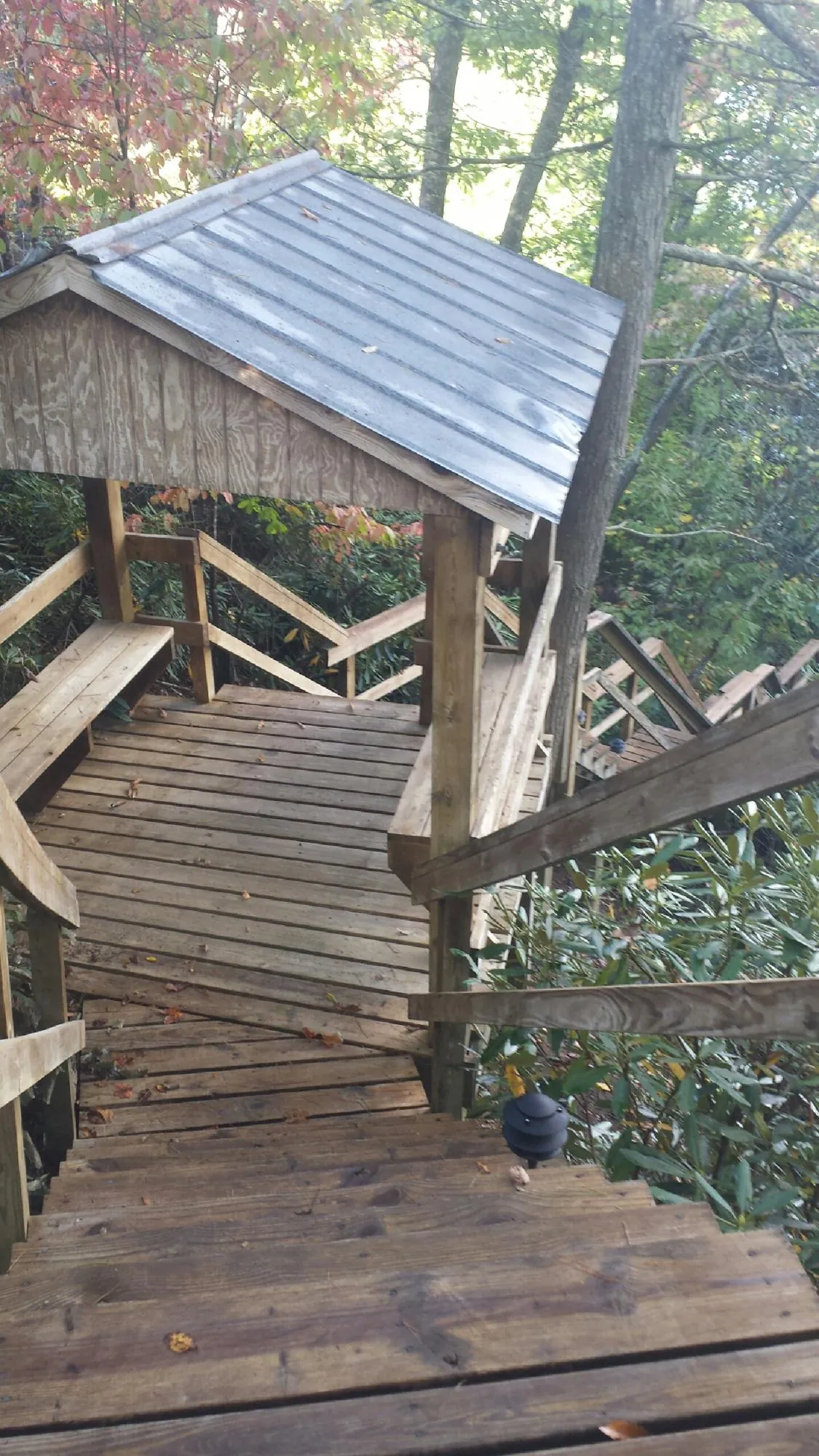 Metal roofed shelter over wooden steps on a wooded walkway — Skylight Repair & Installation work by our crew in East Branch
