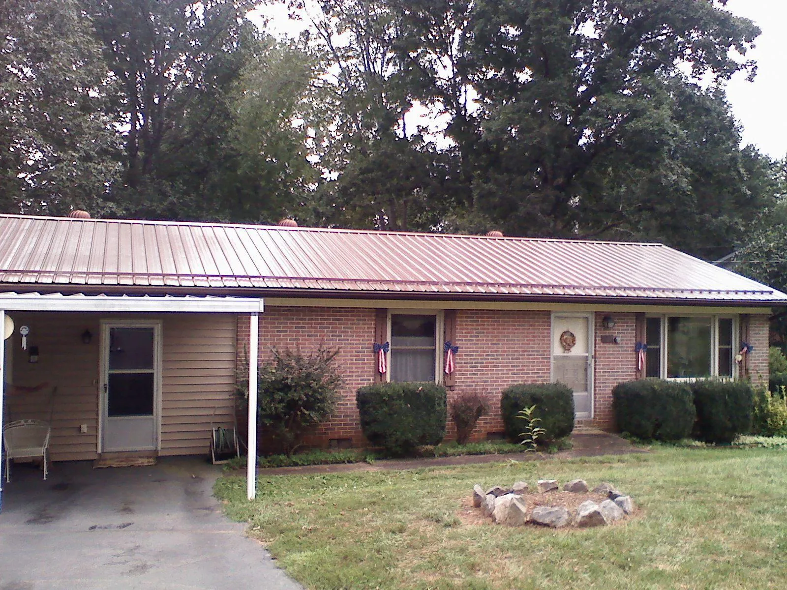 Bronze metal roof and carport on a brick ranch home — Roof Repair work by our crew in East Branch